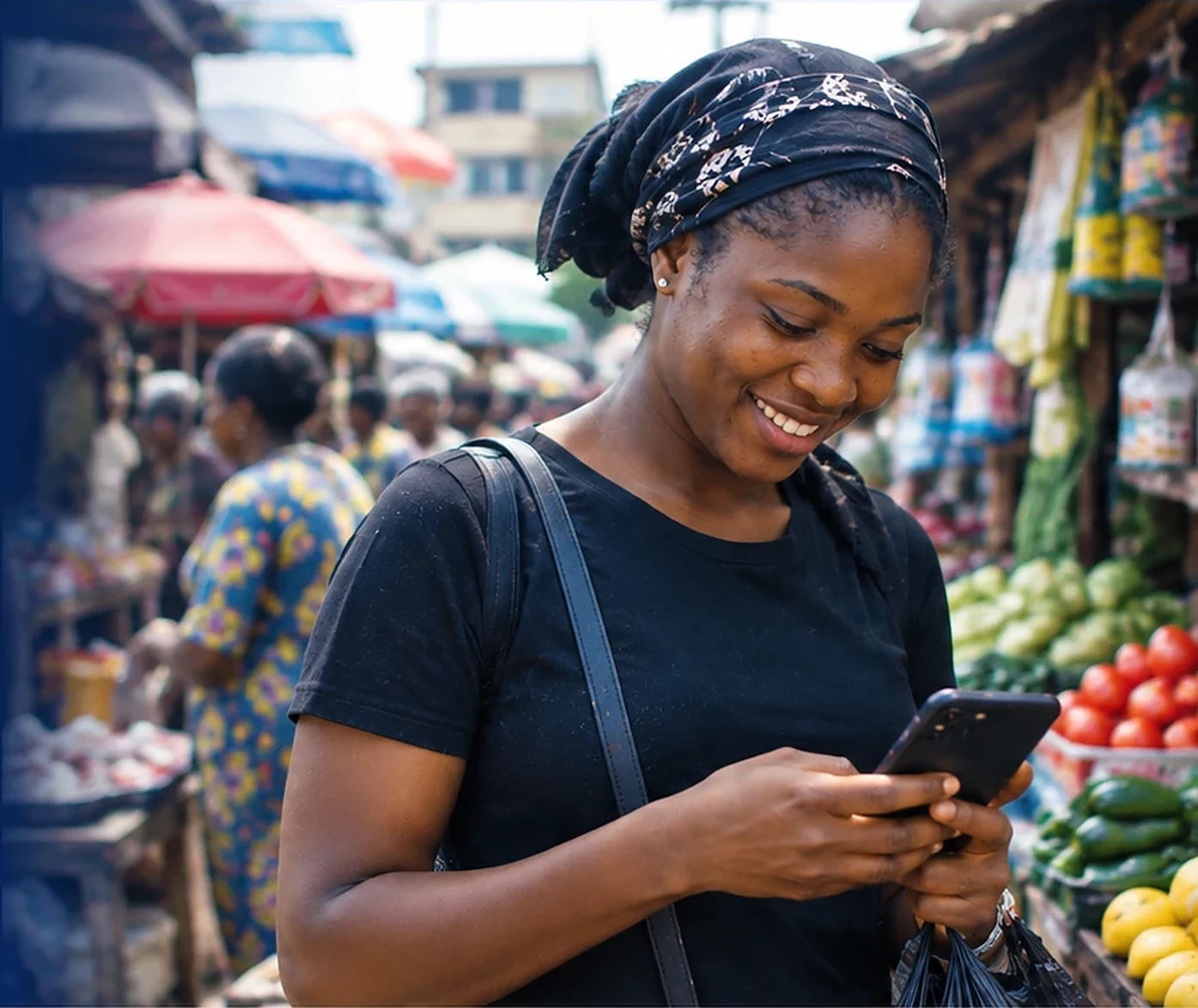 Smiling trader in an open-air Nigerian market checking the Bsb Market app on her phone
